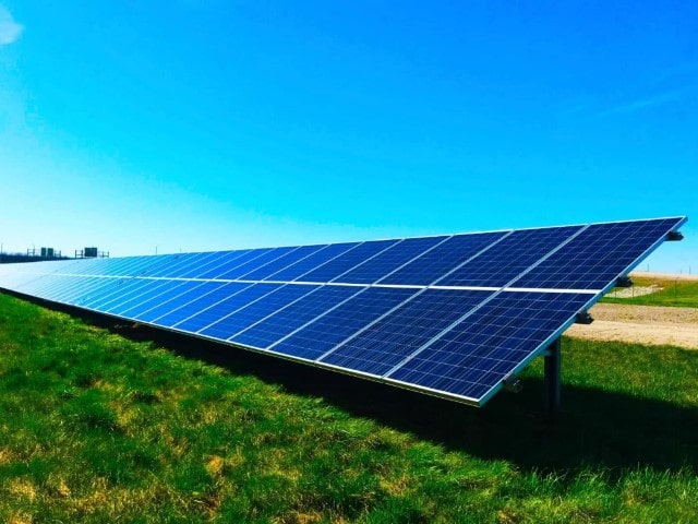 big row of solar panels set up on a field