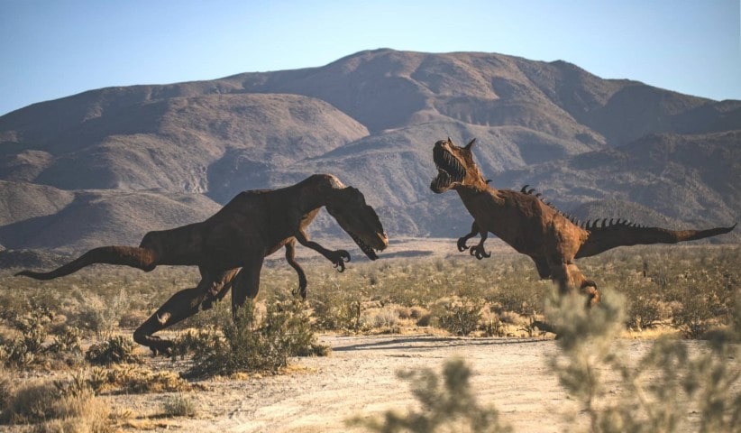 two models of T-rex dinosaurs in the wild